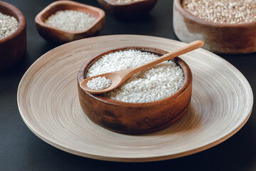 White round rice in a wooden bowl with wooden or bamboo spoon