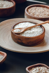 White round rice in a wooden bowl with wooden or bamboo spoon