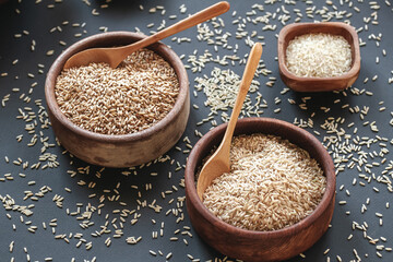 Set of different types of rice and cereals in wooden bowls and bamboo spoon