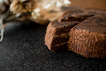 Sliced tasty chocolate cake. Chocolate cake with a cut piece on blurred background, closeup.