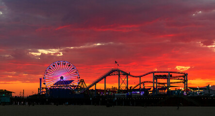 Beautiful and colorful sunset at Santa Monica, with the Pacific Park Amusement Park silhouetted  in...