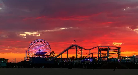 Fotobehang Mooie en kleurrijke zonsondergang in Santa Monica, met het Pacific Park Amusement Park als silhouet op de voorgrond.. © Hélène Sauvageot