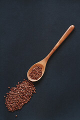 A cereals buckwheat in wooden or bamboo spoon top view