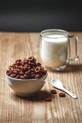 Bowl with chocolate quick breakfast cereal and glass of milk