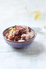 Salad with tuna and cherry tomatoes. Wooden background. Close up. Copy space.	