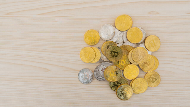 Many bitcoins were piled on the wooden table.