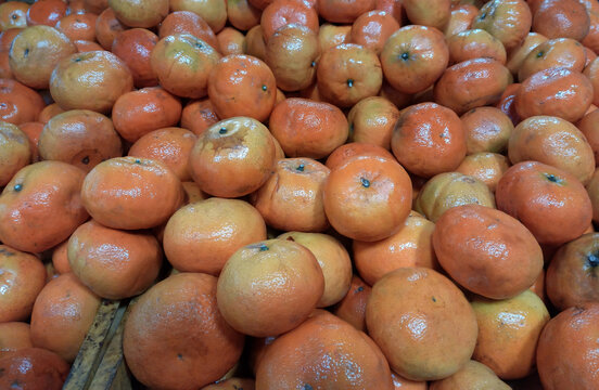 Closeup of juicy ripe orange tangerines (citrus reticula) at the market good as a background
