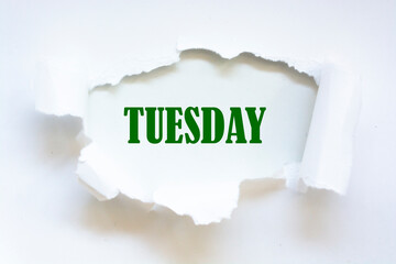 TUESDAY word written under torn paper.