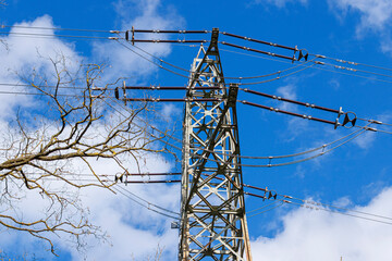 strommast vor blauem himmel mit wolken