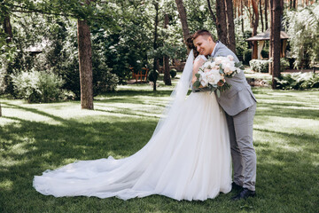Fototapeta premium Walking the bride and groom outdoors. Beautiful summer photo session in nature.