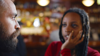 Close up of african woman and caucasian man communicating in restaurant