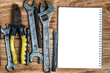 various tools blank notebook wooden background (1)