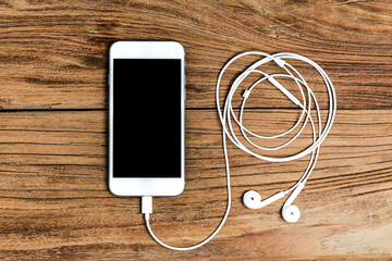mobile phone earphones wooden background