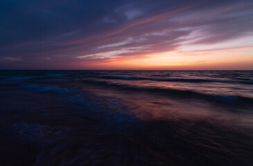 Fototapeta na wymiar Dark Sunset over the sea shore, sandy beach, colorful sky