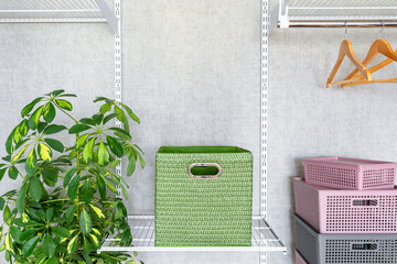 Green box with handles on metal shelf in dressing room. Modern and fashionable wardrobe with metal shelves, storage system clothes