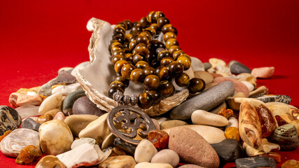 Buddhist prayer beads Mala are the conch shell on the sea rocks surrounded by sea shells. close-up