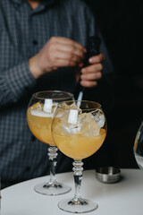 Cocktails with champagne in wine glasses on the bar table in the pub or restaurant with the bartender.