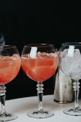 Cocktails with champagne in wine glasses on the bar table in the pub or restaurant with the bartender.