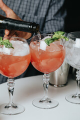 Cocktails with champagne in wine glasses on the bar table in the pub or restaurant with the bartender.
