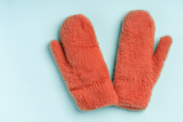 Warm colored winter mittens on a blue background
