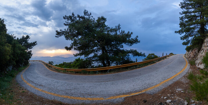 Road curve during cloudy sunset, at Hymettus Mount, the mountain east of the city of Athens, Greece, Europe