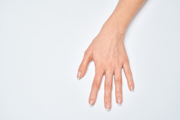 Beautiful Female Hands with French manicure over light grey background