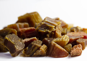 Candied rhubarb on a white background. Dry rhubarb close - up macro photography. Rheum. Dried rhubarb candied fruits