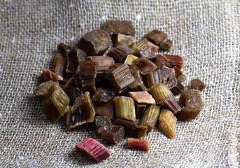 Dried rhubarb candied fruits. Candied rhubarb on a canvas fabric background. Dry rhubarb close - up macro photography. Rheum.