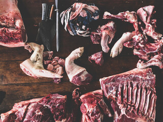 meat raw assortment and knife on the butcher's dark wooden working table. Top view.