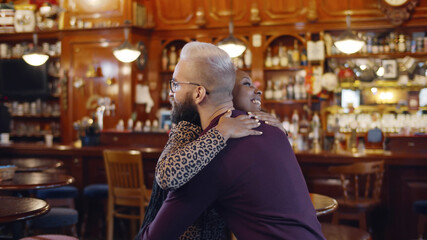 Happy multiethnic man and woman smiling and dancing in restaurant