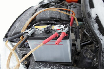 Frozen car engine cold start with spare external battery accumulator and wires with crocodile clips...