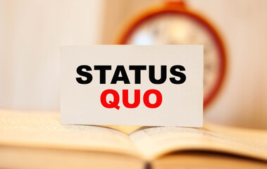 STATUS QUO on the background of a clock on a business card