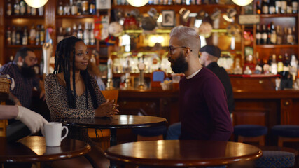 Multiethnic young couple meeting in modern bar