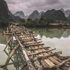 Fototapeta na wymiar Old dangerous abandonned bamboo bridge crossing a river in the Trung Khan District, Cao Bang Province, Vietnam