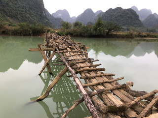 Fototapeta na wymiar Old dangerous abandonned bamboo bridge crossing a river in the Trung Khan District, Cao Bang Province, Vietnam