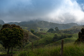 Field landscape of a farm with wire fence in the background fog is seen between the mountains. Colombia .