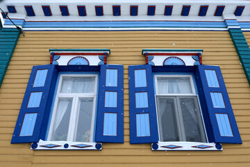 Windows with platbands of wooden house
