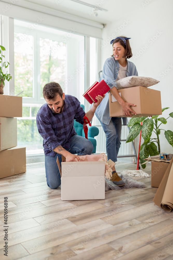 Wall mural Couple carrying cardboard boxes while moving in together