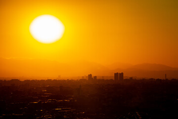 冬の東京の夕暮れの街並みと巨大な夕日