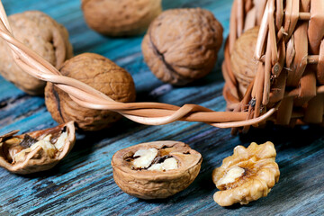 Food background. Walnut close-up. A round walnut spilled from a basket on a blue wooden table.