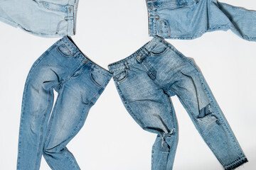 top view of various denim jeans on white background
