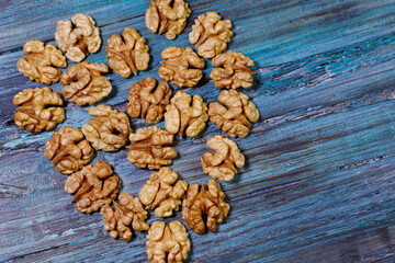 Food background. Peeled walnut close-up. Walnut kernels lie on a blue wooden surface in the shape of a heart.