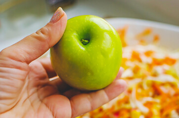 The apple is added to vegetable salad. Home cooking, healthy diet food.