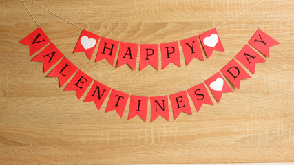 Happy Valentines day red flags garland on wood background with copy space. Love, Valentine's, romantic, rendezvous template