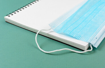 Medical mask on notebook. The concept of purchasing masks and accounting for wearing mask.