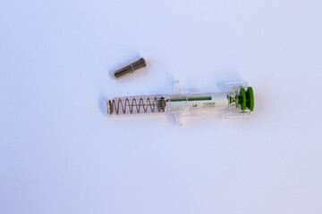 Used injection syringe needle with safety spring needle guard and protective cap for safe sharps disposal. Medical equipment