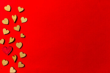 Valentine's day background from wooden and crystal hearts on a red backdrop. Copy space. Love and wedding concept