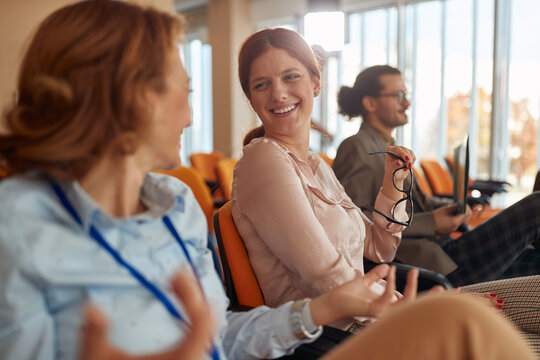 people in conference room at business seminar. two  females talking