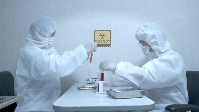 Medium Shot of Two Asian male doctors researchers wearing PPE suit testing and experimenting CORONA Virus, COVID19 vaccine.