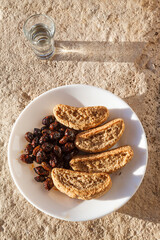 Cretan rusks, olives and tsikoudia (raki), a delicious snack meal as often offered in Crete. All three products are of typical Cretan cuisine.